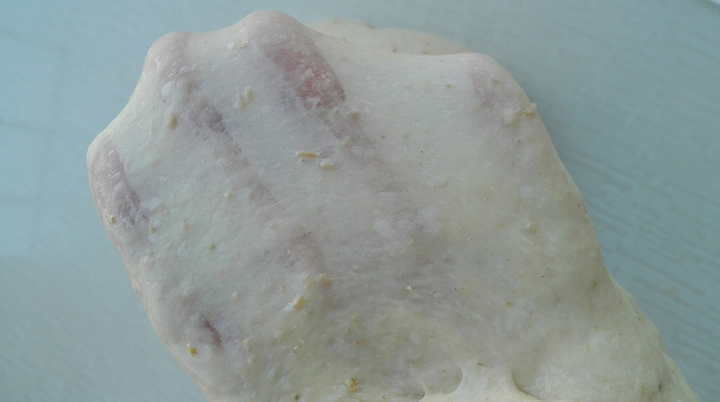 全麦豆沙葡萄干面包,加入软化黄油，揉至薄膜，如图