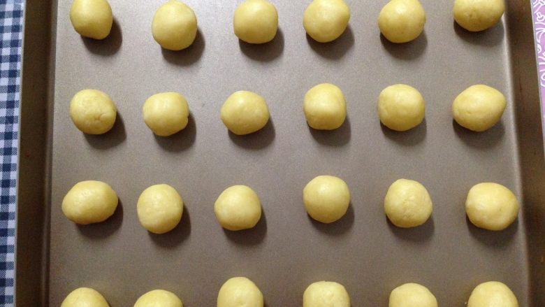 酥脆奶酪球,摆放在烤盘上，每个小球之间留出足够的距离