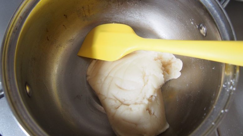 奶油泡芙,倒入过筛后的面粉，快速搅拌至不粘锅，使面粉全部被烫熟。