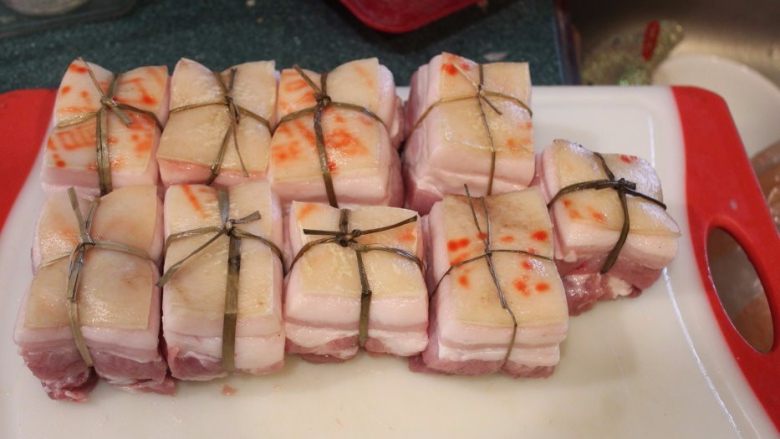 东坡肉,将五花肉用将用传统的閵草绳十字交叉绑好，以防熬软烂后肉块破裂。