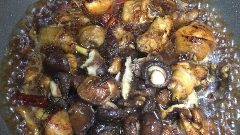 香菇烧鸡块,接着倒入香菇和一碗清水，加盐，盖盖焖烧，一定用小火