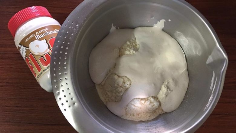 焦糖费南雪,在过筛的粉类中加入Fluff焦糖棉花糖，并用打蛋器混合均匀