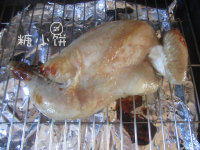 洋葱苹果玫瑰酒烤鸡,表面刷上准备好的蜂蜜玫瑰酒糖水，送入预热好200℃的烤箱中上层，开循环热风