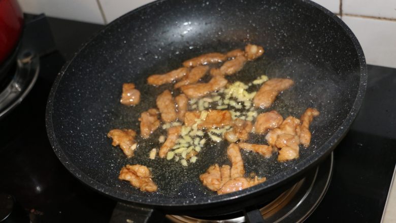 蒜薹小炒,肉片变色后，放入姜末，继续翻炒。