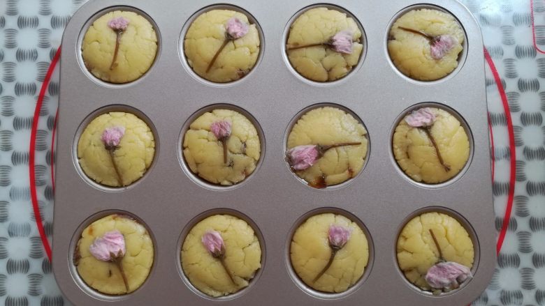 苹果酥,在每一个苹果酥胚上放上一朵樱花装饰，预热烤箱上火130度，下火170度