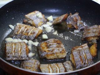 烧带鱼,加入拍碎的大蒜炒出香味。