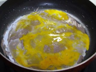 褐麦鸡蛋饼,待面糊即将完全凝固时，磕入一个整鸡蛋，用刮板刮匀。
