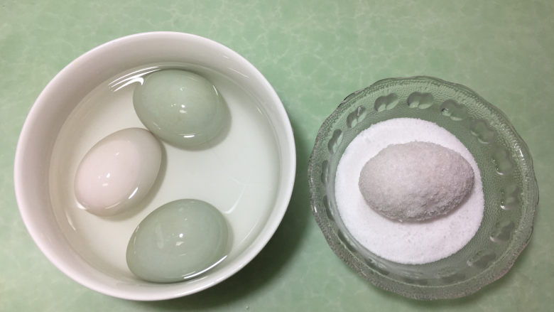 在家也能腌出流油的咸鸭蛋,然后将浸泡好的鸭蛋放入盐碗中，表面都沾满盐。