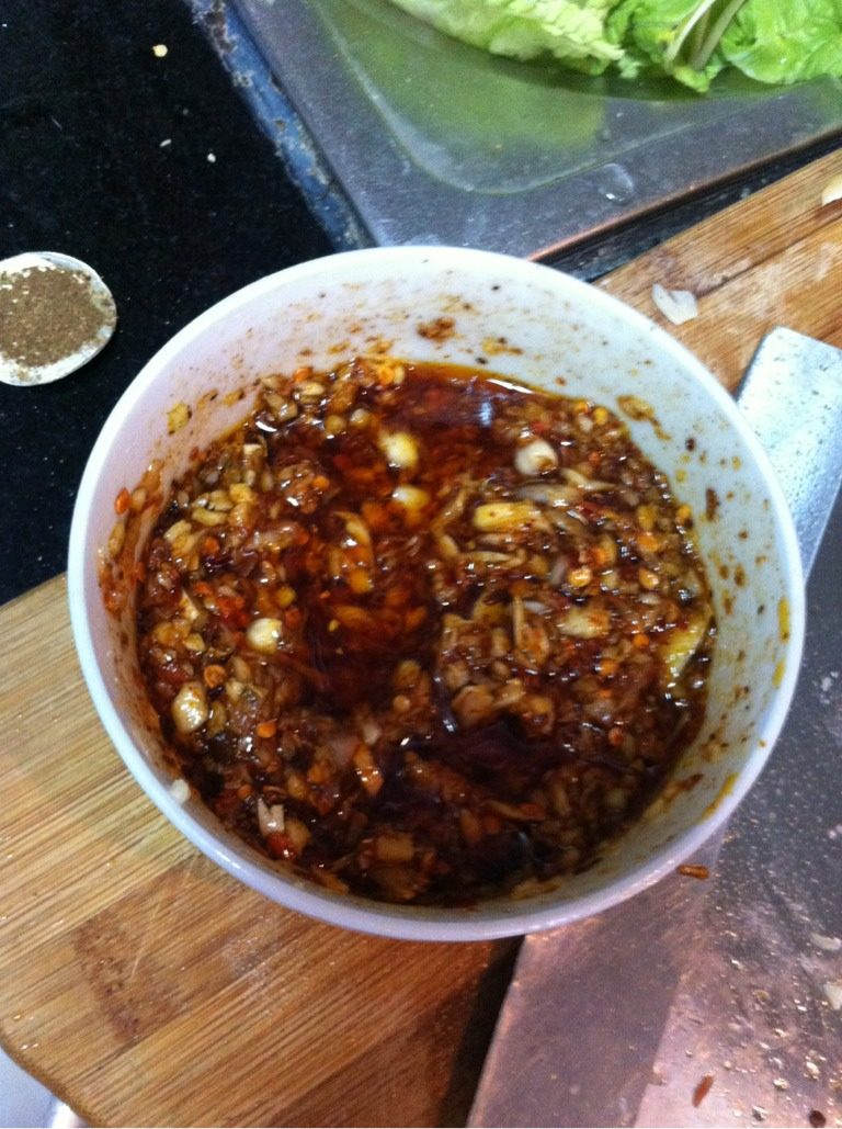 蒜香红油鸭肠,然后将油淋到碗里，拿筷子搅拌均匀