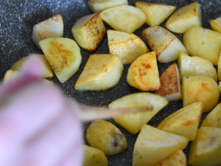 土豆这样做，吃起来口感丰富，外脆里嫩！,中火煎至土豆金黄，用筷子翻面直至两面金黄