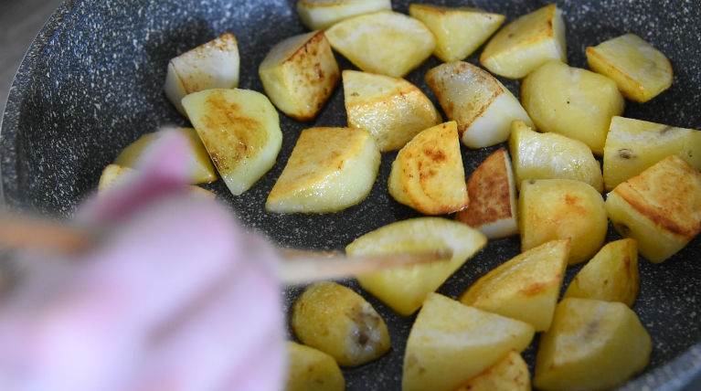 土豆这样做，吃起来口感丰富，外脆里嫩！,中火煎至土豆金黄，用筷子翻面直至两面金黄