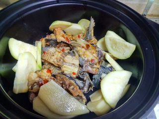 麻辣片片鱼,把煮开的鱼头、鱼骨捞出，放在砂锅里。在把配菜放在里面