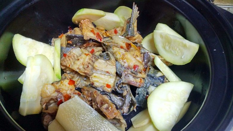麻辣片片鱼,把煮开的鱼头、鱼骨捞出，放在砂锅里。在把配菜放在里面