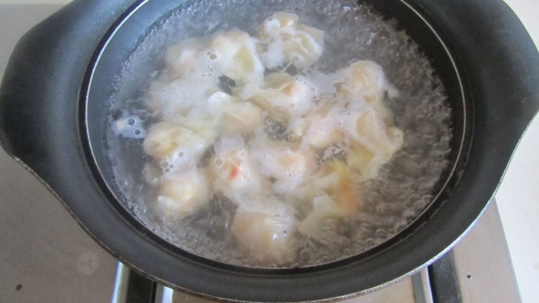 玉米虾仁馄饨,烧锅开水， 加馄饨进去煮， 煮好的馄饨放入碗中，表面撒上小葱末。