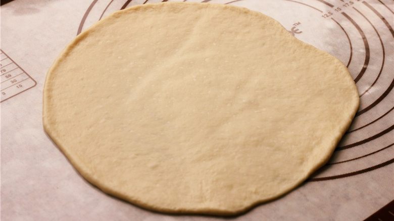 培根玉米粒披萨,取出其中一个，擀成圆形。