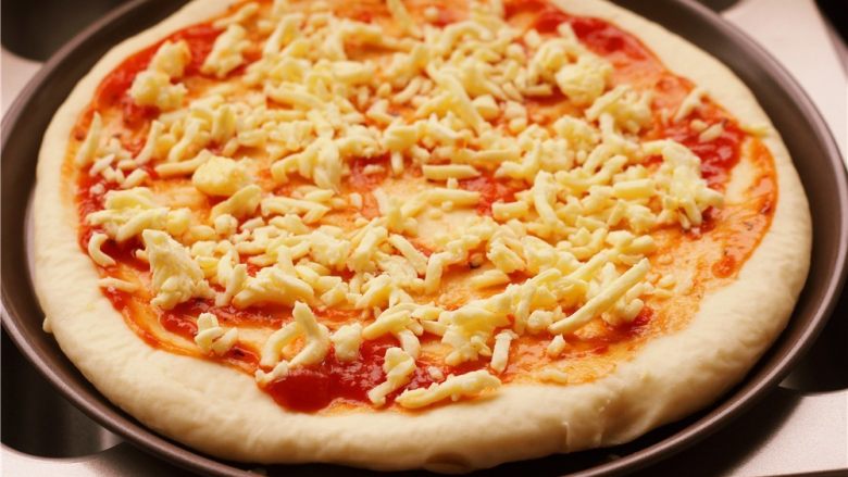 培根玉米粒披萨,撒上一层马苏里拉奶酪。