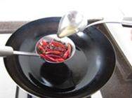 传统水煮牛肉,锅中加入适量花生油，漏勺中放入干红辣椒和花椒，待油烧至 5、6成热时，用汤勺将热油不停浇在花椒和辣椒上，至辣椒变成深造红色、花椒炸酥