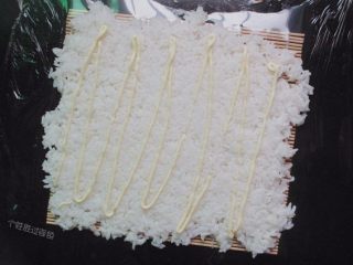 手卷饭团,用饭铲把米饭进行调整铺平，挤上沙拉酱