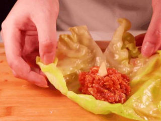 饺子馅的新鲜吃法，比拿来包饺子还要好吃！,取适量的肉馅放入菜叶中间。