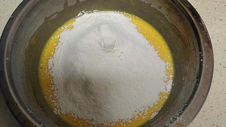 酸 奶 小 蛋 糕 ,往蛋液里加入过筛后的低筋面粉。