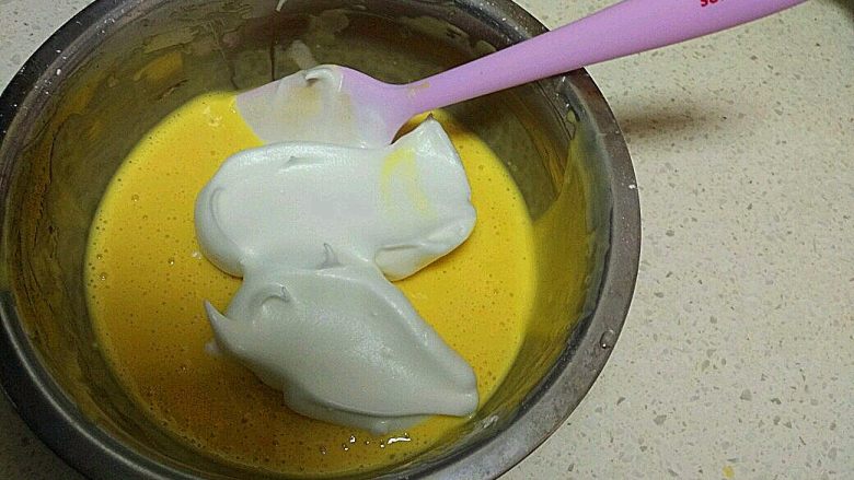 酸 奶 小 蛋 糕 ,将3分之1的蛋白加入面糊中，把蛋白与面糊搅拌均匀。