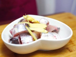 砂锅蒜香焖鮰鱼,姜片放入切好的鮰鱼中