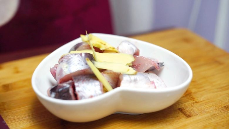 砂锅蒜香焖鮰鱼,姜片放入切好的鮰鱼中