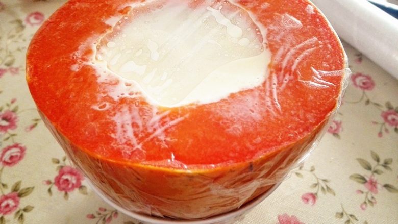 木瓜奶冻,上面盖上保鲜膜，底下放在碗里，这样比较稳，入冰箱冷冻2个小时左右，