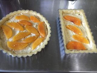黃桃杏仁塔,用小掛刀將餡料整理平整后放入煮過的黃桃片（黃桃片要完全瀝干水分）