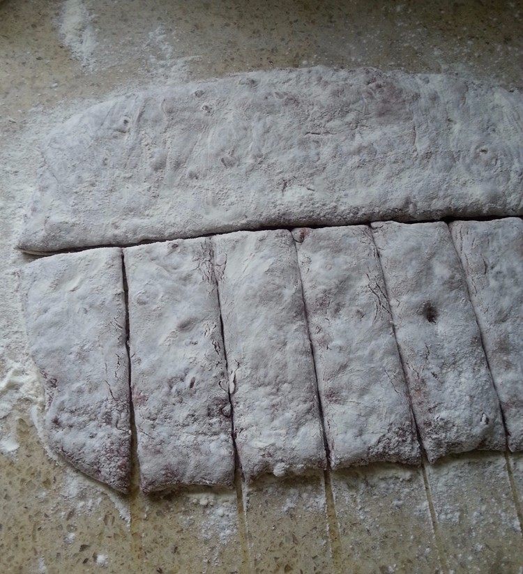 巧克力手拌面包,将面团取出，还是用手拍成约4CM厚的面饼；对半切开，平均分成8等份；