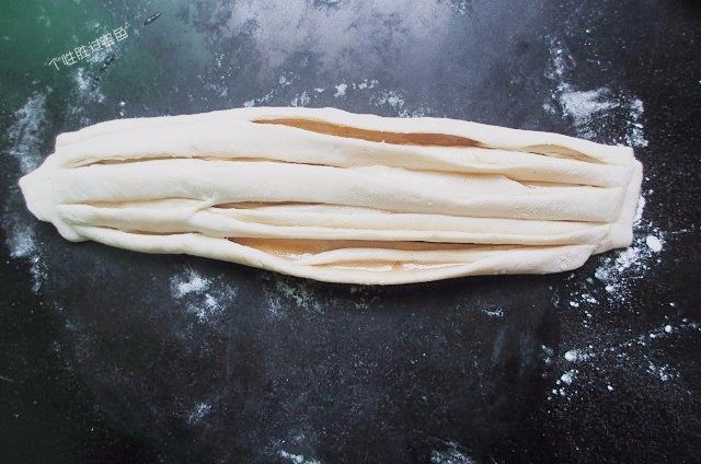 手撕饼,把圆柱形的面团从中间切开，头部留2～3cm不切开方便下一步卷，把两个切面朝上。