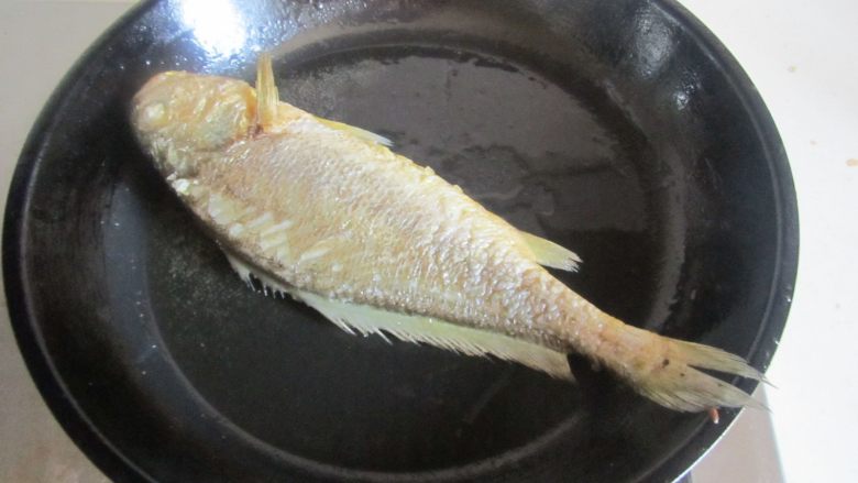 毛豆烧黄鱼,不要急于翻动鱼，晃动下锅，如果鱼能跟着动后将鱼翻一面也煎至金黄；