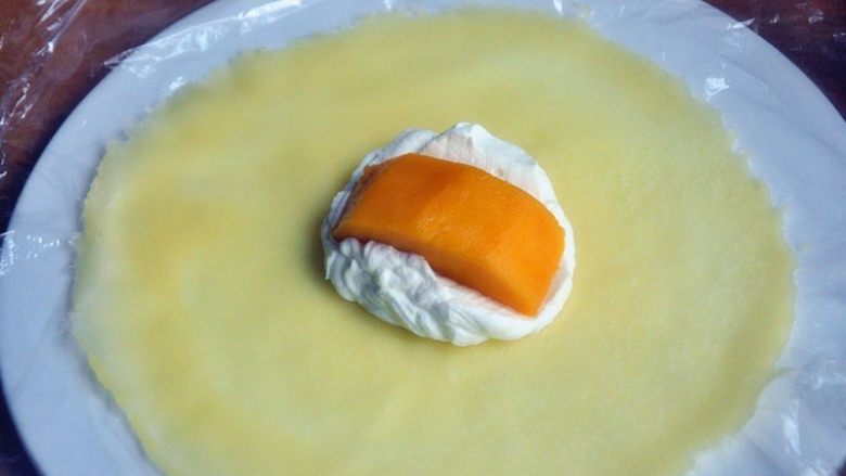 芒果班戟,放一块芒果，然后再盖一层奶油在芒果上面。
