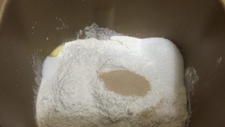 卡路里炸弹 咕咕霍夫重油面包, 将除黄油和酒渍果干以外的所有的材料放入面包桶中，启动和面功能25分钟