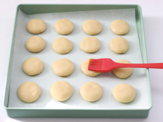 芝麻小酥饼,先用刷子蘸鸡蛋液，均匀的涂抹一遍。