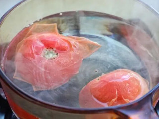 金针菇番茄汤,番茄洗净在表面划十字刀，将划刀位置朝下放入沸水中烫二十秒左右。
