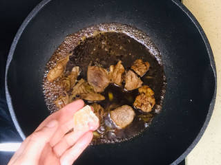 猪肉烧板栗,扔进一块冰糖，转中火，炖煮至猪肉八成熟