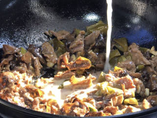 酸辣椒炒牛肉,淋入生抽、老抽、淀粉水，翻炒均匀