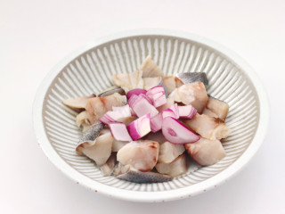 蒜香牙签鳕鱼,把鳕鱼洗净后切小块放入容器中，洋葱去皮后切片放入容器里。
