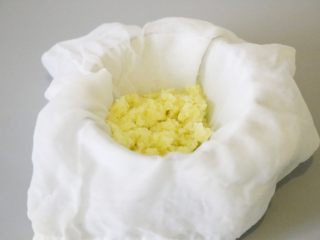 自制姜撞奶,调整将生姜泥置于纱布中间。