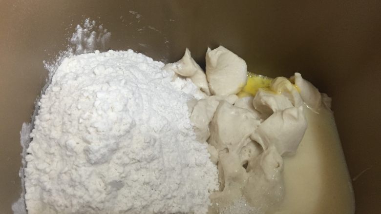 炼奶提子吐司,将中种面团直接剪成小块后加入主面团中除黄油和葡萄干以外的所有的材料，面包机揉面30分钟