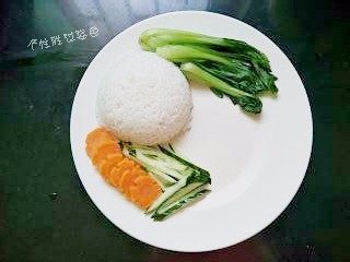 秘制鸡腿饭,把米饭倒扣在盘子里，摆上胡萝卜片、青菜、黄瓜丝