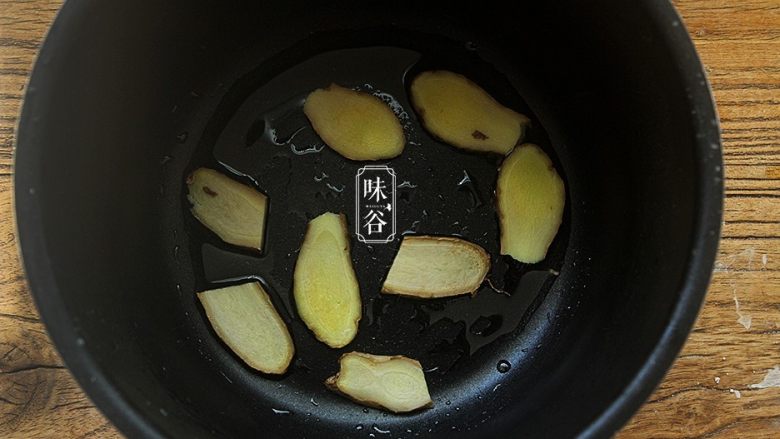简单方便的电饭煲可乐鸡翅,在电饭锅里倒入1汤匙食用油，放进姜片抹匀油；