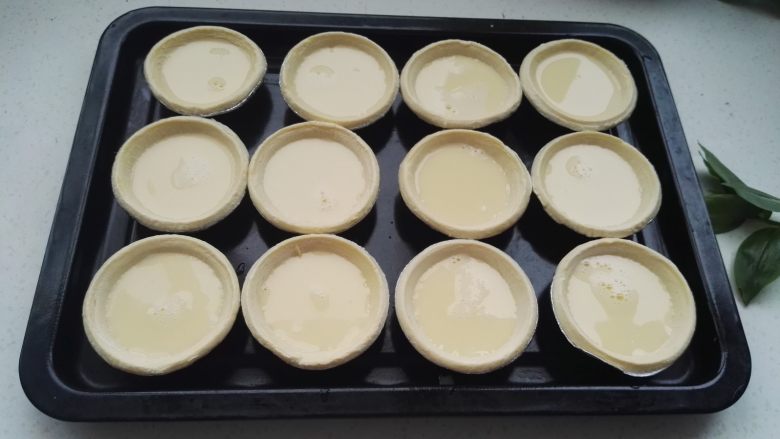 炼乳蛋挞,把蛋挞液均匀的倒入生坯中，倒8分满，太多容易溢出。