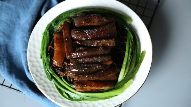 传统秘制 梅干菜扣肉,倒扣碗后，用绿叶蔬菜装饰，就可以吃啦。