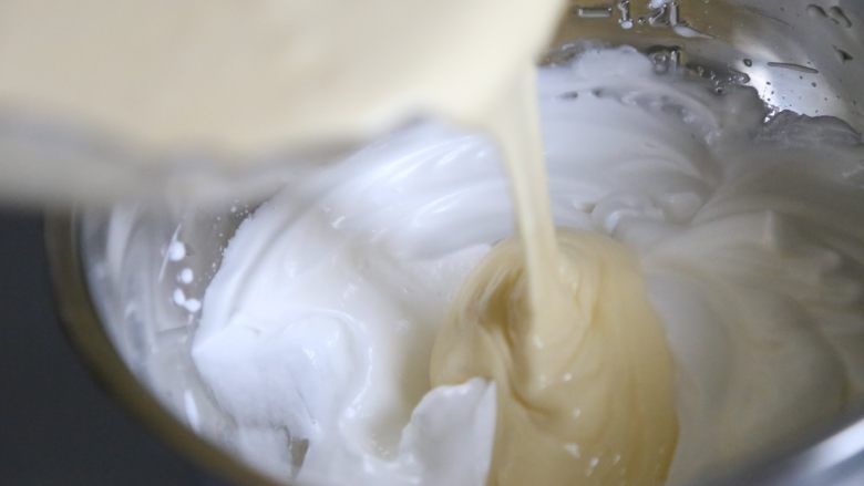 轻乳酪蛋糕,将1/3蛋白放入蛋黄糊里，用刮刀翻拌均匀；再把翻拌好的蛋黄糊全部倒入蛋白糊里，同样上下翻拌方式，搅拌均匀。