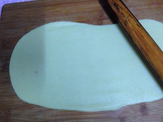 牛奶小饼干,把面团放在案板上，擀成厚约0.3Cm的长方形面片
