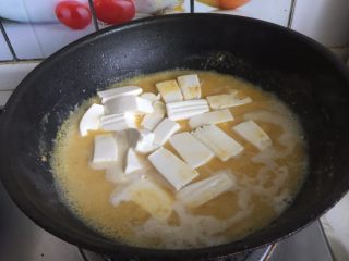 咸蛋黄虾仁豆腐,倒入豆腐块，煮5分钟左右