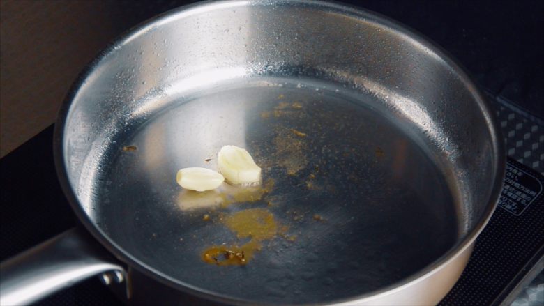 低温慢煮 sous-vide 油封鸭腿配,锅里剩下的油用来煎配菜。先放两粒大蒜头。