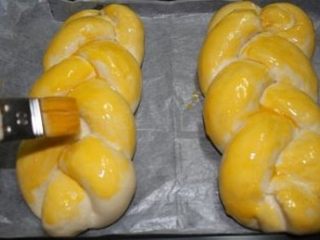 奶香大辫子面包,取出发酵好的面包，刷上一层鸡蛋液再撒上杏仁片